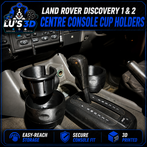 Two black 3D-printed cup holders installed on a car center console, shown next to the gear shift selector. The image features promotional text overlays from 'Lu's 3D' highlighting compatibility with Land Rover Discovery 1 & 2 and listing product features.